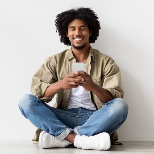 Happy Black Man Messaging On Smartphone