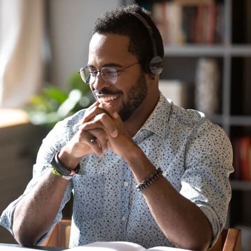 Happy millennial african american man in glasses wearing headphones