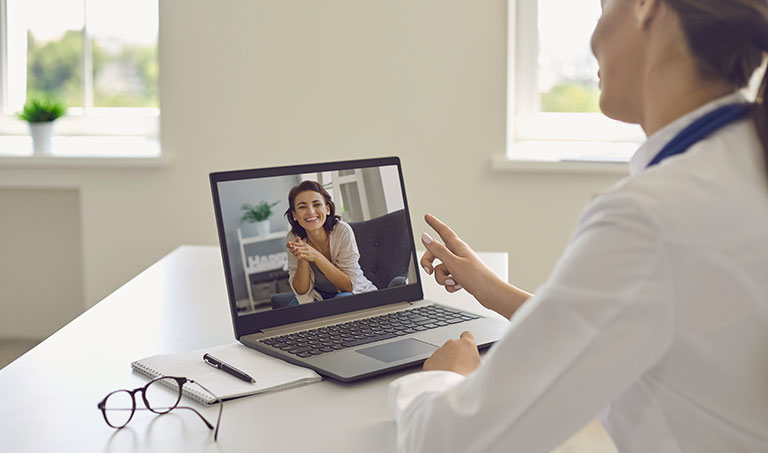 Doctor consults patient online using laptop